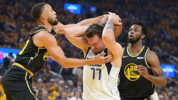 May 18, 2022; San Francisco, California, USA; Dallas Mavericks guard Luka Doncic (77) is defended by Golden State Warriors guard Stephen Curry (30) and forward Andrew Wiggins (22) during the first quarter in game one of the 2022 western conference finals at Chase Center. Mandatory Credit: Kyle Terada-USA TODAY Sports